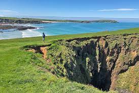 Photo of cliff-top overlooking the sea, with a huge hole in the ground